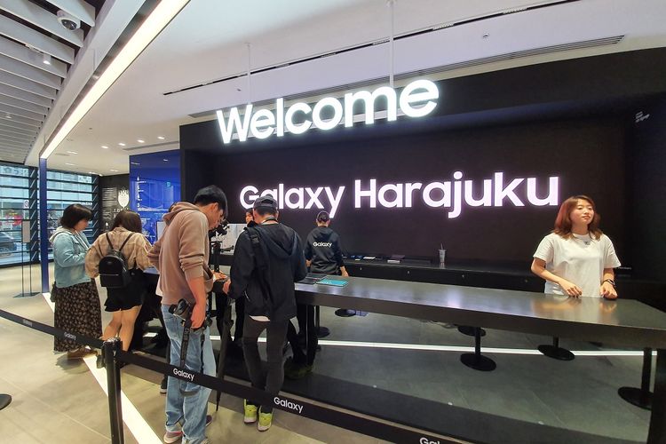 Meja kasir Galaxy Store Harajuku, Jepang, dengan latar layar besar bertuliskan welcome to Galaxy Harajuku. 