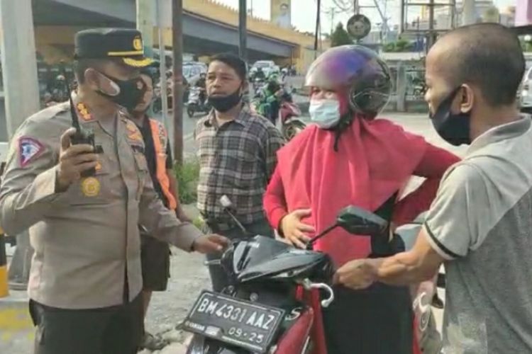 Dirlantas Polda Riau Kombes Pol Firman Darmansyah saat membantu seorang ibu hamil yang kesakitan karena mau melahirkan di pertigaan Jalan Jenderal Sudirman-Imam Munandar, Kota Pekanbaru, Riau, Jumat (30/7/2021).