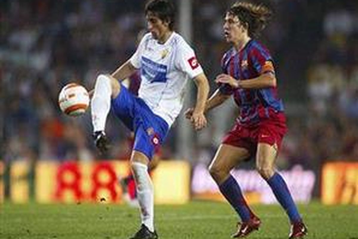Diego Milito (kiri), mendapat kawalan dari bek Barcelona, Carles Puyol. Ini merupakan penampilan Milito bersama Real Zaragoza saat mereka masih mentas di Primera Division.