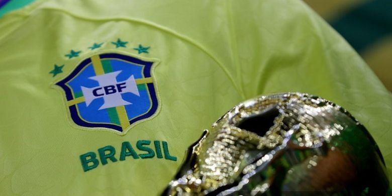 Seorang suporter Brasil mengenakan kostum timnas Brasil dan replika trofi Piala Dunia ketika menyaksikan aksi negaranya melawan Kamerun dalam penyisihan Grup G Piala Dunia 2022 pada 2 Desember 2022 di Lusail Stadium, Lusail, Doha, Qatar. Ada lima bintang di atas lambang timnas Brasil yang menandakan mereka sudah lima kali juara Piala Dunia.