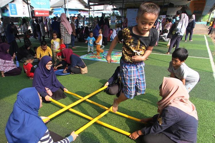 Sejumlah anak dari komunitas permainan tradisional Indonesia bermain tari bambu dalam perayaan Hari Anak Nasional (HAN) 2018 di taman baca masyarakat kolong flyover , Ciputat, Tangerang Selatan, Banten, Minggu (22/7/2018).