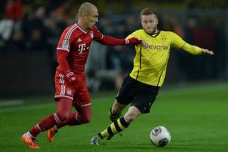 Arjen Robben mencoba melewati Jakub Blaszczykowski dalam pertandingan lanjutan Bundesliga antara Borussia Dortmund kontra Bayern Munchen yang berlangsung di Stadion Signal Iduna Park, Dortmund, Minggu (24/11/2013) dini hari WIB