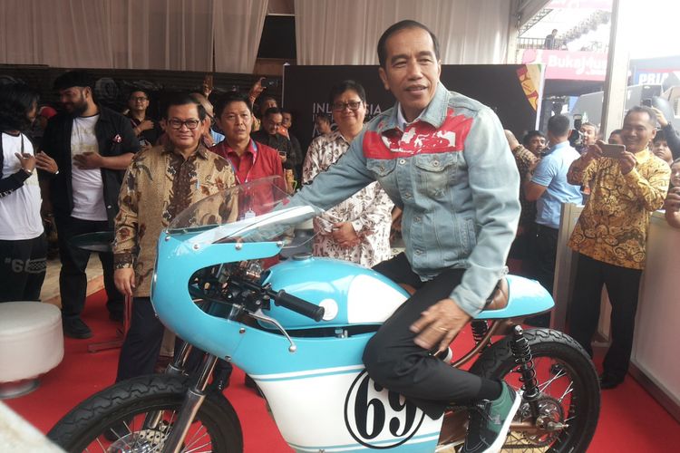 Presiden Joko Widodo menaiki salah satu sepeda motor Honda CB 125 lawas yang dipamerkan di stan Increase saat berlangsungnya hari pertama pameran Indonesia International Motor Show (IIMS) 2018, di JIExpo Kemayoran, Jakarta, Kamis (19/4/2018). Motor yang dimodifikasi bergaya caferacer merupakan milik putra sulung Jokowi, Gibran Rakabuming.