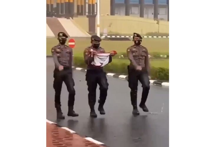 Tangkapan layar video viral disertai dengan narasi sejumlah anggota polisi di Riau menurunkan bendera merah putih saat hujan badai.