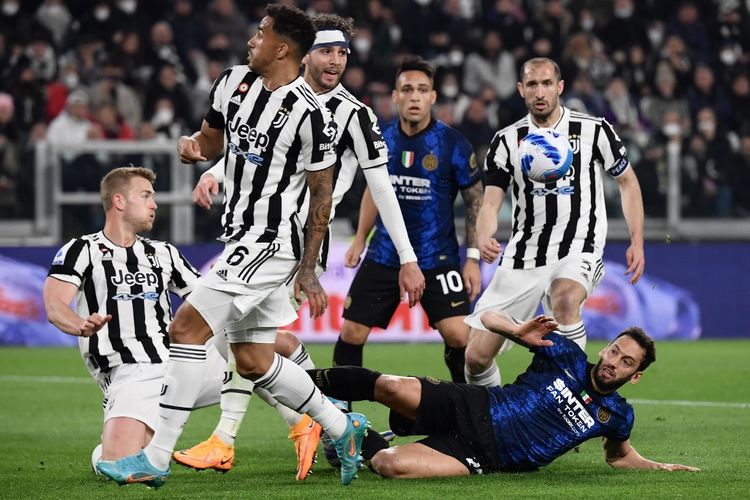 Bek Juventus Matthijs De Ligt (kiri) menggagalkan tendangan gelandang Inter Milan Hakan Calhanoglu (kanan bawah) dalam pertandingan Juventus vs Inter Milan pada pekan ke-31 Liga Italia 2021-2022 di Stadion Allianz, Senin (4/4/2022). 