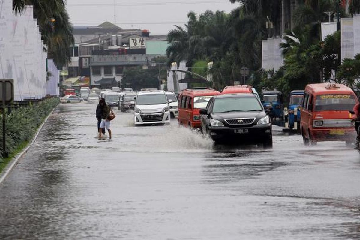 Pengendara melintasi genangan di Jalan boulevard, Kelapa Gading  Jakarta Utara, Jumat (17/1/2014). Hujan lebat mengguyur Jakarta sejak pagi, membuat sejumlah jalanan Ibukota tergenang. 