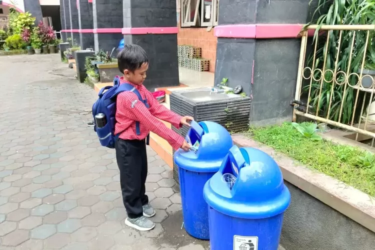 Seorang siswa sembuang sampah pada tempat yang disiapkan di salah satu sekolah Kota Mataram, Provinsi Nusa Tenggara Barat. 