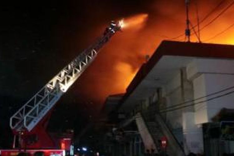 Pemadam kebakaran kesulitan untuk memadamkan kobaran api yang terus melalap Pasar Klewer, Solo, Sabtu (27/12/2014) malam. 