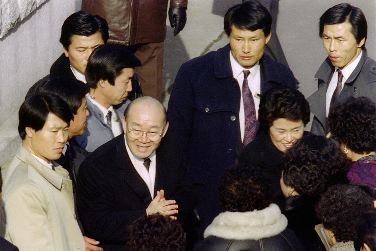Mantan presiden Korea Selatan Chun Doo-hwan (dua dari kiri) dan istrinya, Lee Son-ja, disambut para pendukungnya saat pulang ke rumah pada 30 Desember 1990 di Seoul. Chun dan istrinya dua tahun tinggal di pengasingan kuil Buddha terpencil, setelah mereka diburu oleh banyak orang yang memprotes.