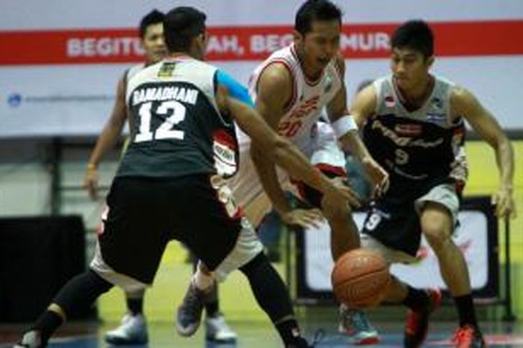 Kapten Garuda Kukar Bandung, Wendha Wijaya (jersey putih, tengah) dihadang pemain Aspac Jakarta, saat berlaga di GOR Bimasakti, Malang, Minggu, (24/11/2013).