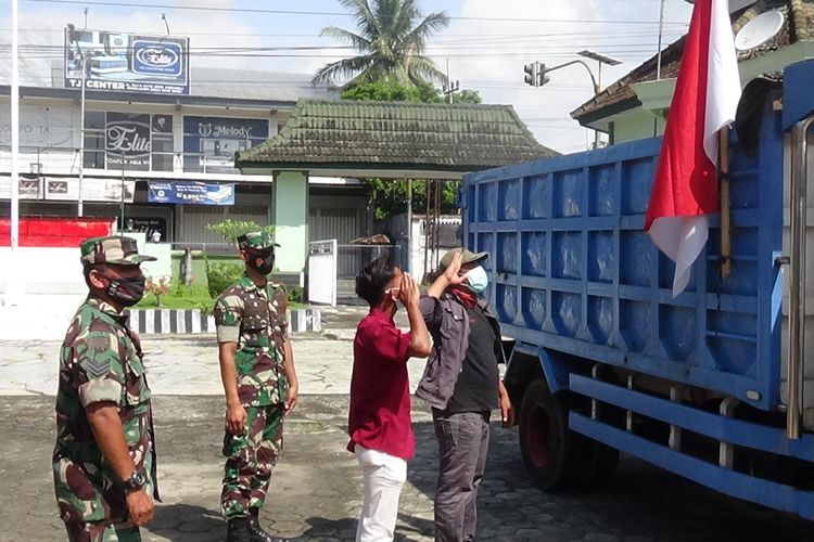 Sopir truk asal Kecamatan Rogojampi, Banyuwangi, Jawa Timur, Faisal Pratama (20) dan rekannya bersikap hormat kepada Bendera Merah Putih, di Markas Ramil 0825/12 Rogojampi, Minggu (9/1/2022). Dok Markas Ramil 0825/12 Rogojampi