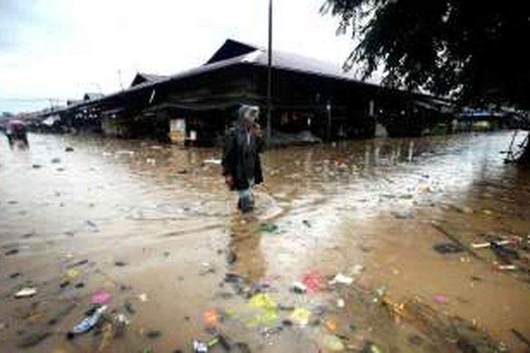 Banjir di Pasar Induk Gedebage - Warga melintasi genangan banjir yang penuh sampah di Pasar Induk Gedebage, Kota Bandung, Jawa Barat, Rabu (2/11/2016). Buruknya drainase serta sampah membuat kawasan pasar ini terendam banjir setelah hujan lebat mengguyur Kawasan Bandung Utara.