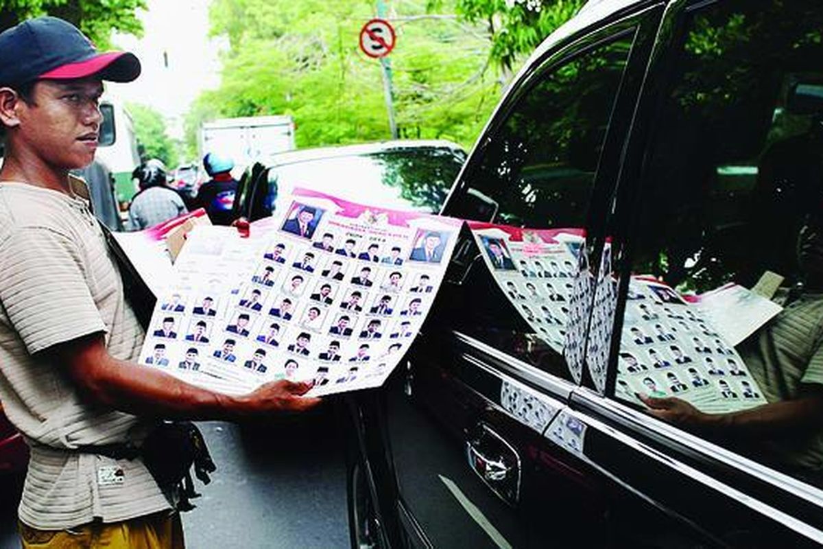 Terbentuknya kabinet baru memberi rezeki bagi mereka yang jeli melihat peluang dan cepat mengambil aksi mencetak poster susunan kabinet, termasuk pedagang asongan yang menjajakannya kepada pengendara mobil di Jalan Prof Moch Yamin, Jakarta, Sabtu (24/10).