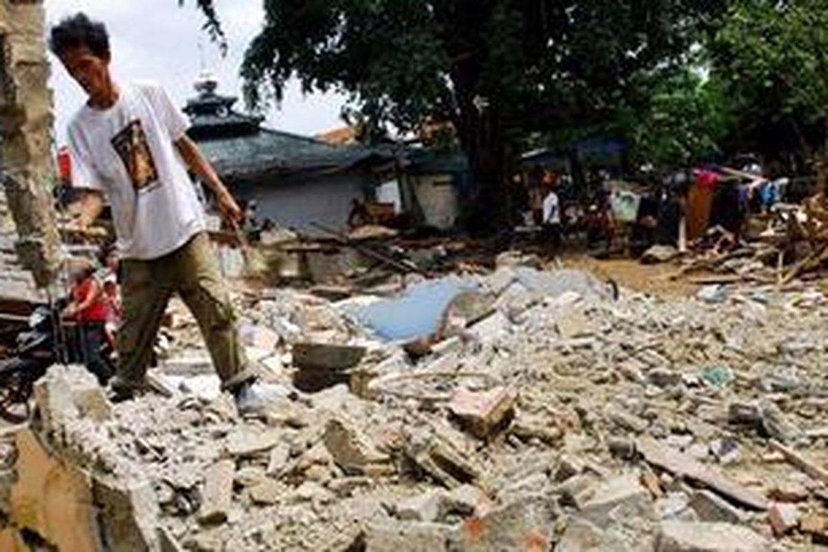 Ilustrasi : Seorang warga ikut membersihkan sisa-sisa puing bekas bangunan yang telah dihuninya selama puluhan tahun. Rumahnya ikut digusur Satpol PP karena menyalahgunakan fungsi lahan sebagai pemakaman, Rabu (14/12/2011) 