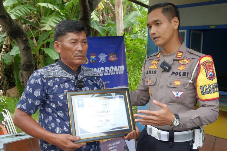 Kasatlantas Polres Lamongan AKP Aristianto Budi Sutrisno (kanan), saat memberikan penghargaan kepada Gufron yang didapuk sebagai duta keselamatan jalan oleh Polres Lamongan, Kamis (9/2/2023).