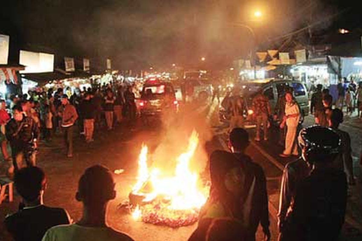Pedagang oleh-oleh di Kampung Pamucatan, Nagreg, Bandung, Jawa Barat, memblokir jalan dengan membakar ban dan keranjang peuyeum serta membuka jalur dua arah di Nagreg lama sebagai bentuk protes atas pemberlakuan arus balik Lebaran melewati jalur lingkar Nagreg, Sabtu (3/9). Mereka meminta jalur Nagreg lama dibuka lagi sebagai jalur arus balik. Sejak dibukanya jalur lingkar Nagreg, mereka merugi karena tidak ada pembeli.