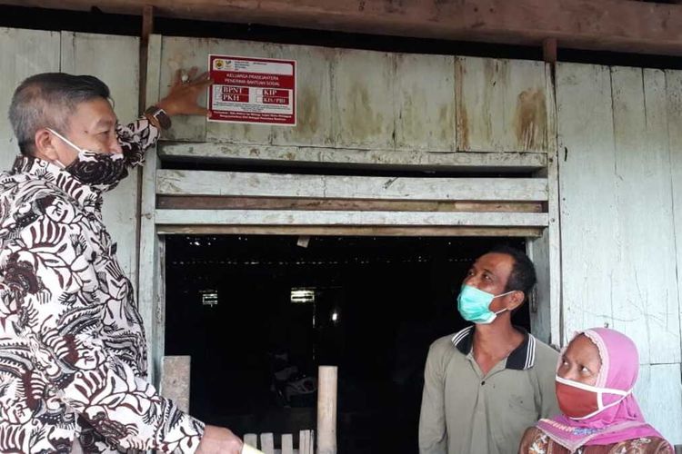 Kepala Dinas Sosial Kabupaten Grobogan, Jawa Tengah, Edy Santoso beserta jajarannya ikut melakukan pemasangan stiker di rumah penerima bansos di wilayah Kabupaten Grobogan, Jumat (26/2/2021).