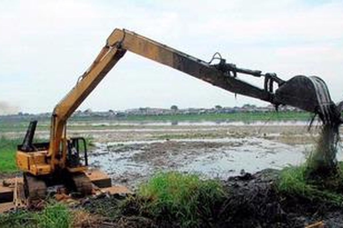 Pekerja mengeruk endapan Waduk Pluit di Penjaringan, Jakarta Utara, Minggu (31/3/2013). Luas genangan waduk diperkirakan berkurang dari 80 hektar menjadi sekitar 60 hektar akibat maraknya hunian liar dan tingginya laju sedimentasi.
