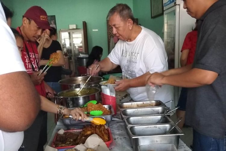 Om kim pemilik dari warung Nasi Uduk & Ketupat Sayur Encim Sukaria, Tangerang sedang melayani salah satu pengunjung.