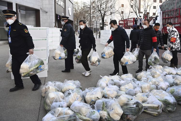 Petugas subdistrik mengantarkan paket makanan gratis ke rumah-rumah warga yang terdampak lockdown di Xi'an, provinsi Shaanxi, Rabu (29/12/2021). Pemerintah China menjanjikan suplai makanan yang stabil ke Xi'an yang dihuni 13 juta penduduk untuk menekan penyebaran Covid-19. Lockdown Xi'an adalah yang terketat di China sejak ditutupnya Wuhan saat awal pandemi.