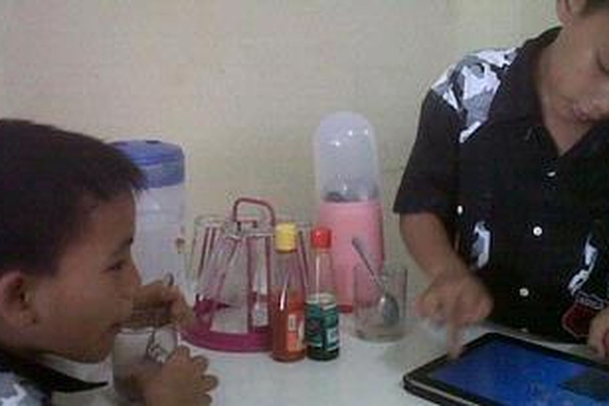 Timothy dan Miracle, kakak dari dua bayi kembar yang tewas dalam ember sedang bermain ketika menunggu ibunya, Nova Wurangian yang terus diperiksa di Mapolresta Manado.