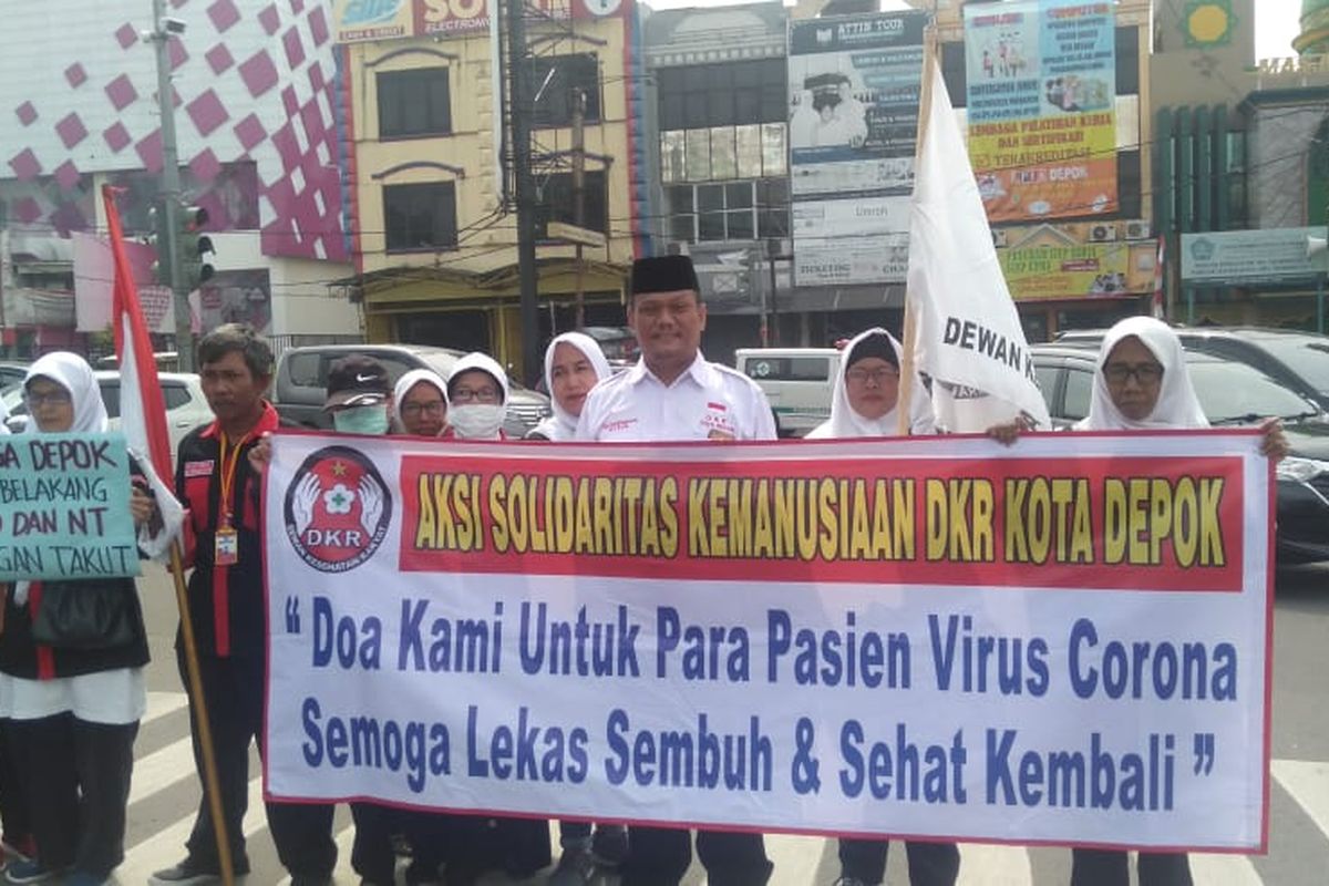 Dewan Kesehatan Rakyat (DKR) Kota Depok menggelar aksi solidaritas dan doa bersama sebagai bentuk dukungan moral terhadap dua pasien positif virus corona asal Depok. Aksi digelar di Simpang Ramanda, Jalan Margonda Raya, Depok, Jawa Barat, Kamis (12/3/2020).