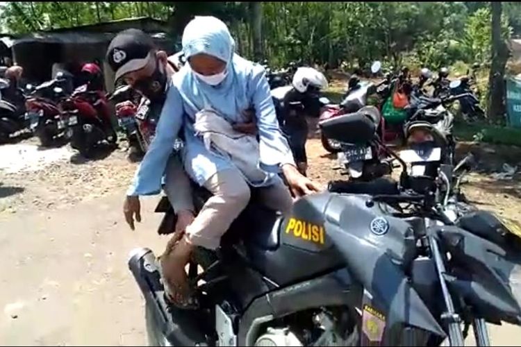 Bripka Budi Suwito menggendong lansia untuk vaksinasi Covid-19