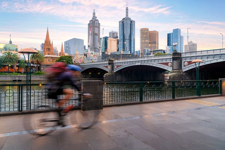 Orang Australia bersepeda untuk olahraga di sekitar Sungai Yarra dengan pemandangan kota Melbpourne City Financial District dengan pencakar langit pada pagi hari di Melbourne, Victoria, Australia.