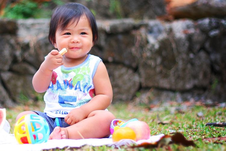 Ilustrasi bayi sedang menikmati camilan.