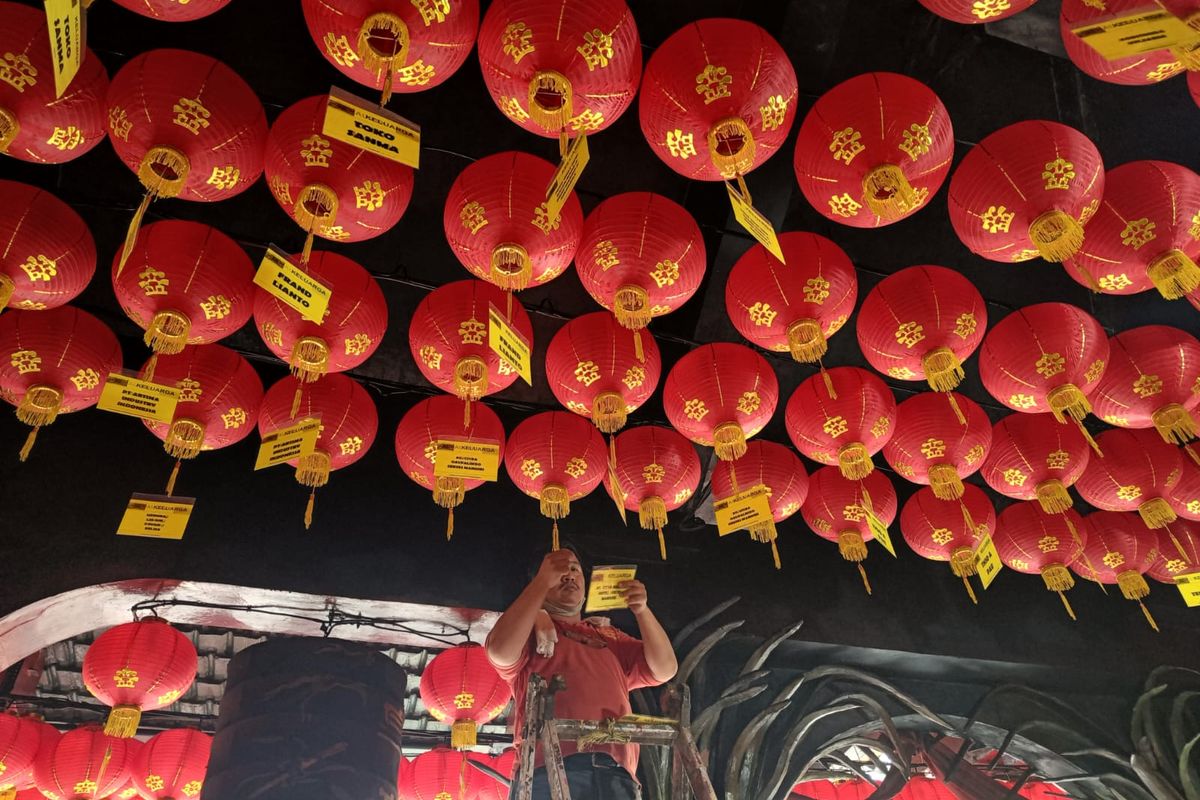 Seorang petugas sedang memasang nama di lampion yang akan dipasang di langit-langit Vihara Nimmala Boen San Bio Kota Tangerang, Rabu (19/1/2023). Pemasangan nama dan lampion-lampion ini dilakukan dalam rangka merayakan tahun baru China atau Imlek 2023.