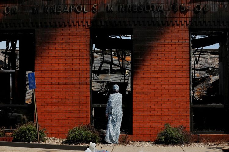 Warga lokal memeriksa kantor pos terbakar yang dihancurkan saat demonstrasi yang terus berlangsung memprotes kematian George Floyd saat ditahan oleh polisi Minneapolis, di Minneapolis, Minnesota, Amerika Serikat, Minggu (31/5/2020). ANTARA FOTO/REUTERS/Lucas Jackson/wsj/cfo