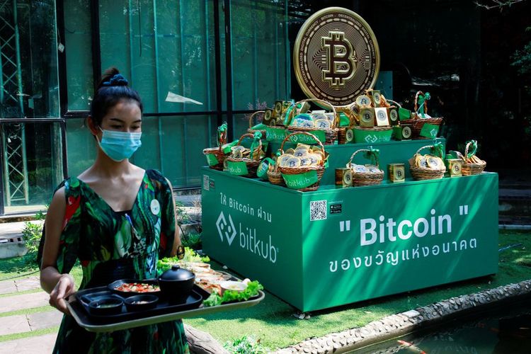 Logo Bitcoin terlihat di sebuah kafe kripto yang memiliki puluhan layar yang menampilkan tren dan harga terbaru berbagai cryptocurrency untuk pelanggan investor crypto mereka di Nakhon Ratchasima, Thailand, Jumat (21/1/2022). 