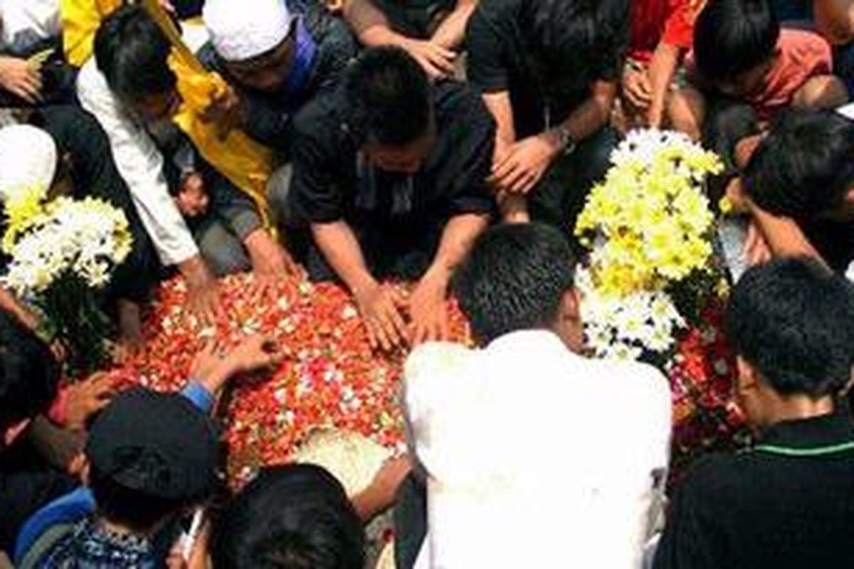 Keluarga dan teman mengantar kepergian Deny Yanuar (17), korban tawuran antarpelajar SMA Yayasan Karya 66 dengan SMK Kartika Zenni yang dimakamkan di TPU Menteng Pulo, Jakarta Selatan, Kamis (27/9/2012). Siswa kelas XI SMA Yayasan Karya 66 itu tewas akibat terkena sabetan celurit di bagian rusuk kiri dan pinggang 