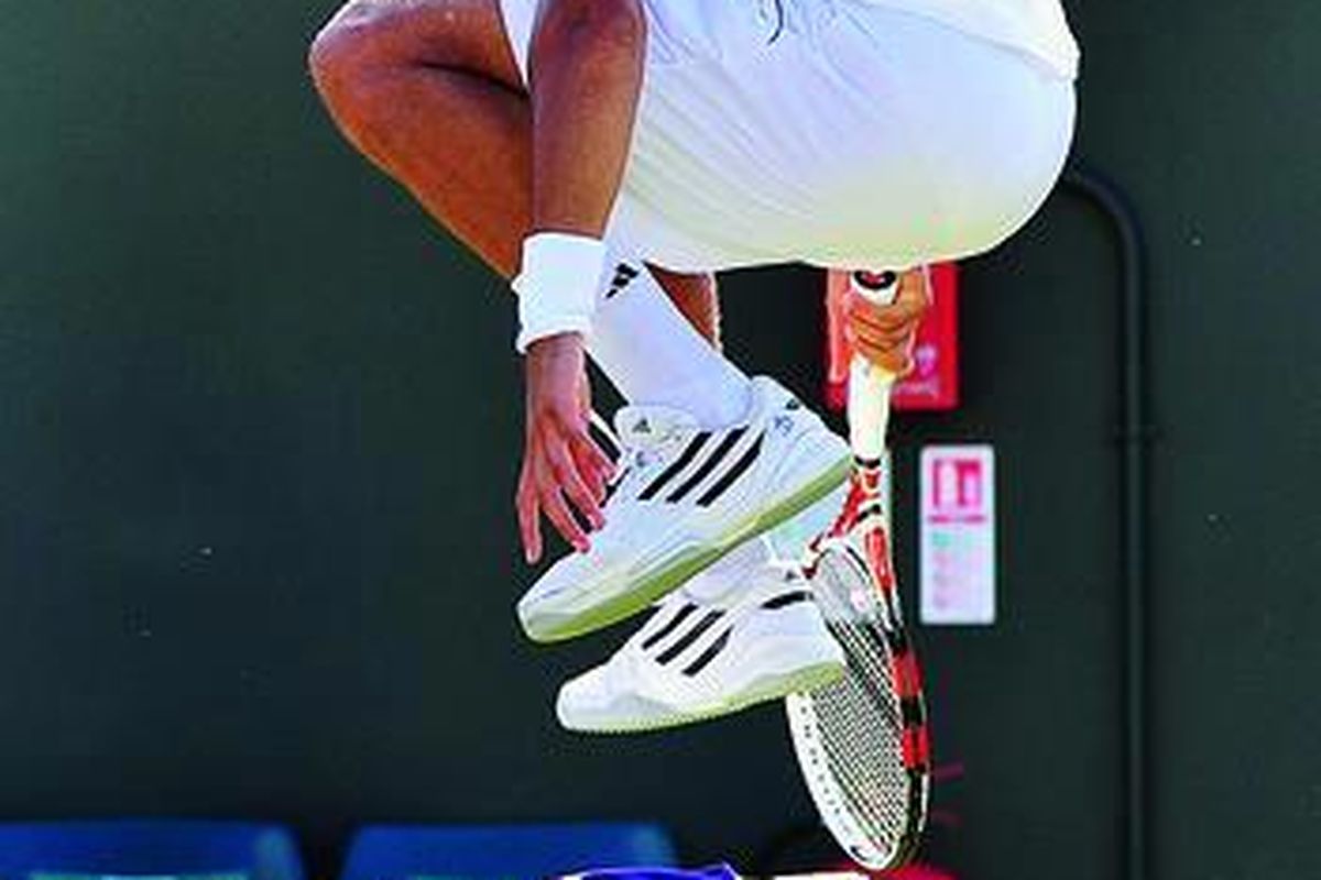 Pemain Perancis, Jo-Wilfried Tsonga, melompati kursi saat bermain melawan petenis Cile, Fernando Gonzalez, pada  Kejuaraan Wimbledon di London, Inggris, Sabtu (25/6).