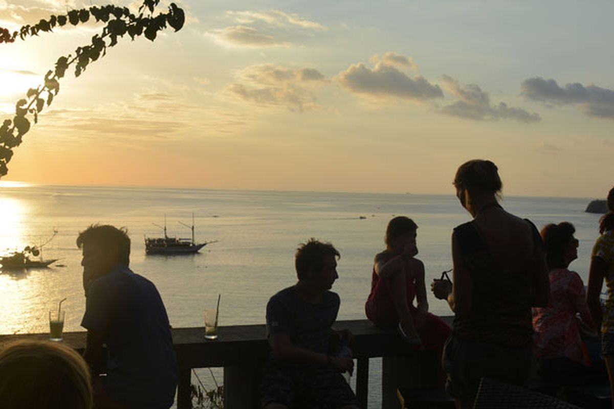 Turis asing sedang duduk di Restoran Paradise Labuan Bajo, Nusa Tenggara Timur, Minggu (27/8/2017) untuk menunggu matahari terbenam di ujung barat Pulau Flores. 