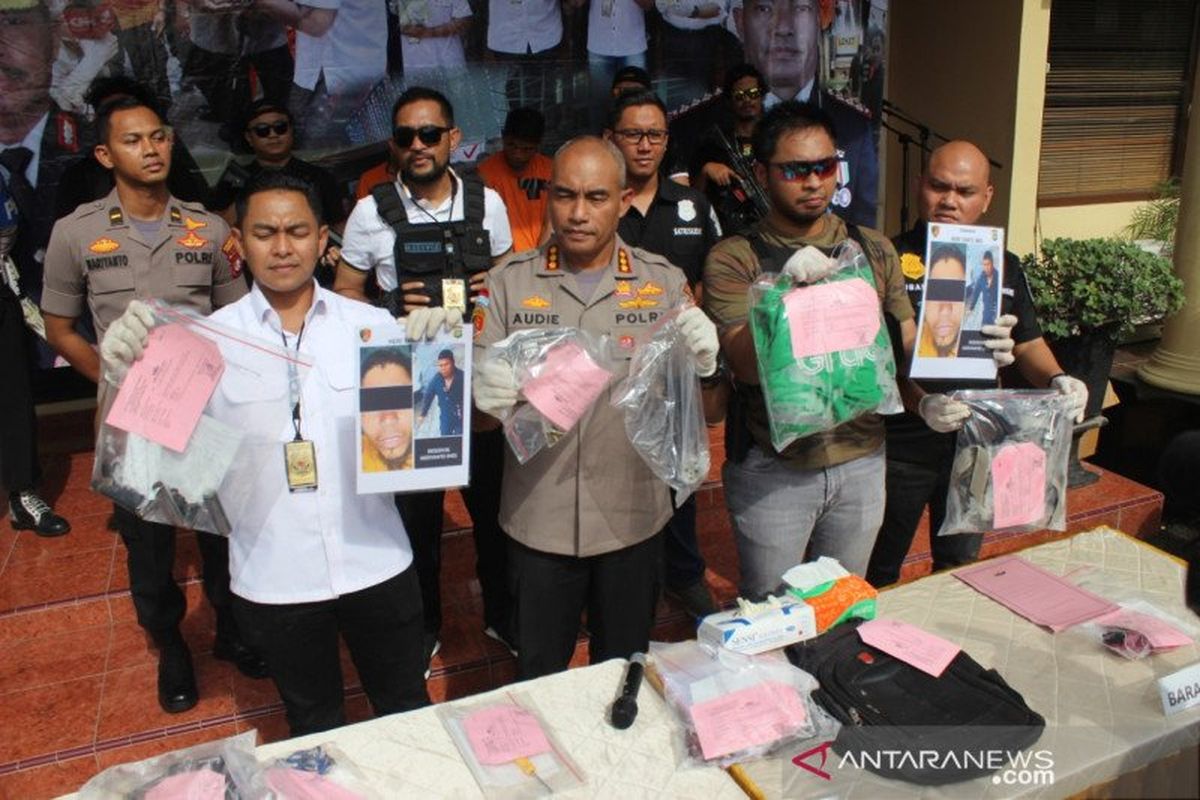 Polisi menunjukkan barang bukti pelaku perampokan bersenjata dan foto pelaku HO yang ditembak mati di Mapolres Metro Jakarta Barat, Selasa (4/2/2020). 