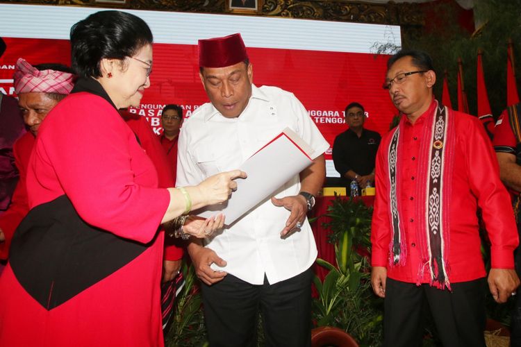 Ketua Umum PDIP Megawati Soekarnoputri (kiri) menyerahkan surat rekomendasi kepada pasangan bakal calon gubernur dan wakil gubernur Maluku Murad Ismail (tengah) dan Barnabas Orno (kanan) seusai mengumumkan bakal calon gubernur dan wakil gubernur empat daerah di DPP PDIP, Jakarta, Minggu (17/12). PDIP resmi mengusung pasangan Arsyadjuliandi Rachman-Suyatno pada Pilgub Riau, Asrun-Hugua pada Pilgub Sulawesi Tenggara, Marianus Sae-Emilia Nomleni pada Pilgub NTT, dan Murad Ismail-Barnabas Orno pada Pilgub Maluku. ANTARA FOTO/Rivan Awal Lingga/ama/17