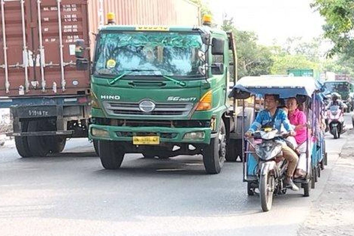 Sejumlah odong-odong membawa penumpang ibu-ibu dan anak-anak menantang maut dengan beroperasi di antara truk kontainer di Jalan Raya Cilincing, Kecamatan Cilincing, Jakarta Utara, Rabu (27/7/2022).  