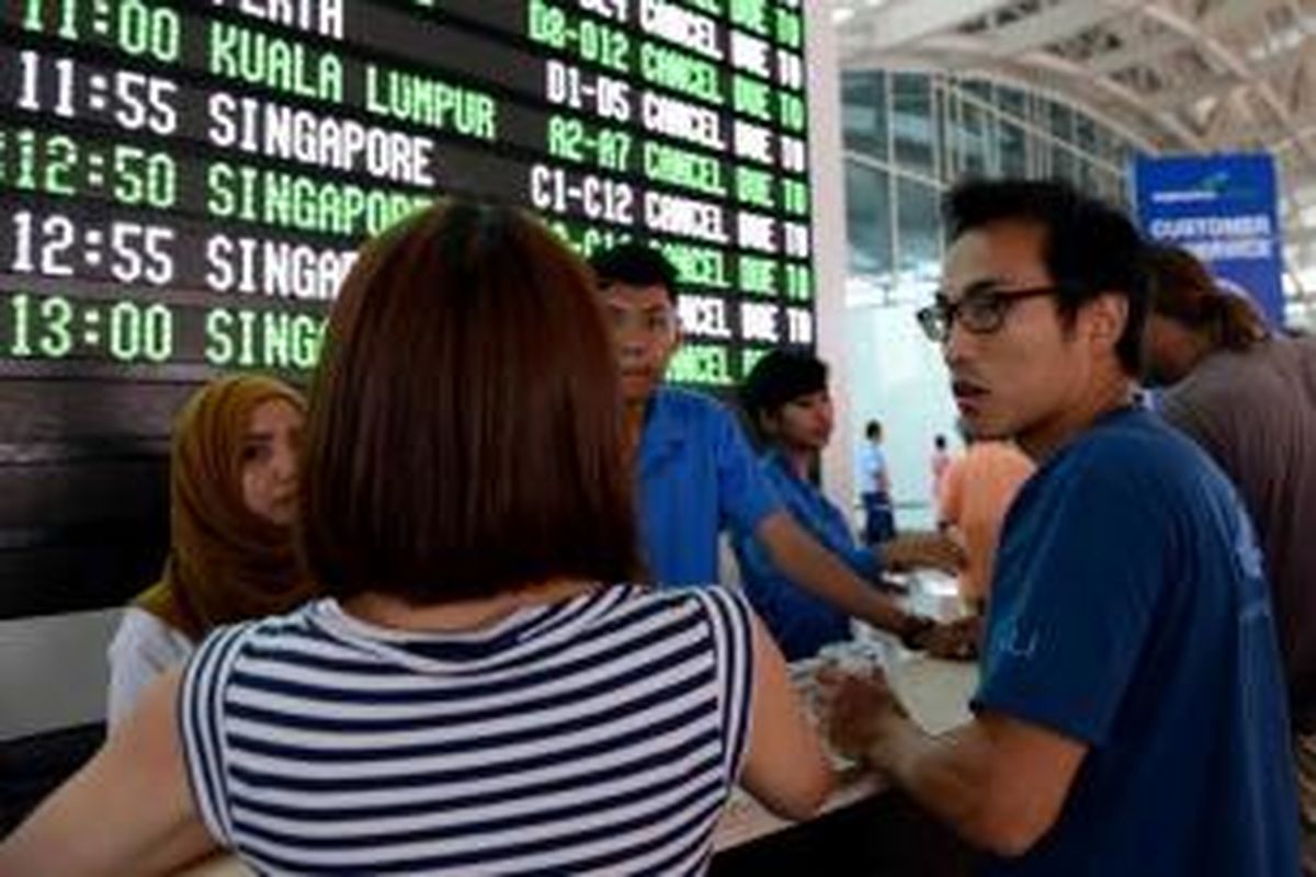 Penumpang menunggu informasi mengenai penerbangan yang ditunda dan dibatalkan di area keberangkatan Bandara Internasional Ngurah Rai, Denpasar, 4 November 2015. Penutupan bandara diperpanjang aktivitas Gunung Barujari yang meningkat. Debu vulkaniknya yang menuju Bali dinilai membahayakan penerbangan.