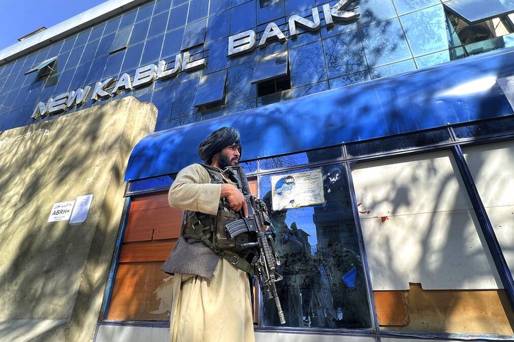 Taliban berjaga di luar sebuah bank, di Kabul, Afghanistan, Minggu, 13 Februari 2022. 