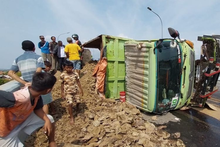 Truk dump yang mengangkut material tanah urugan terguling di flyover jalur selatan di Desa Dermoleng, Kecamatan Ketanggungan, Brebes, Jawa Tengah, Rabu (14/6/2023).