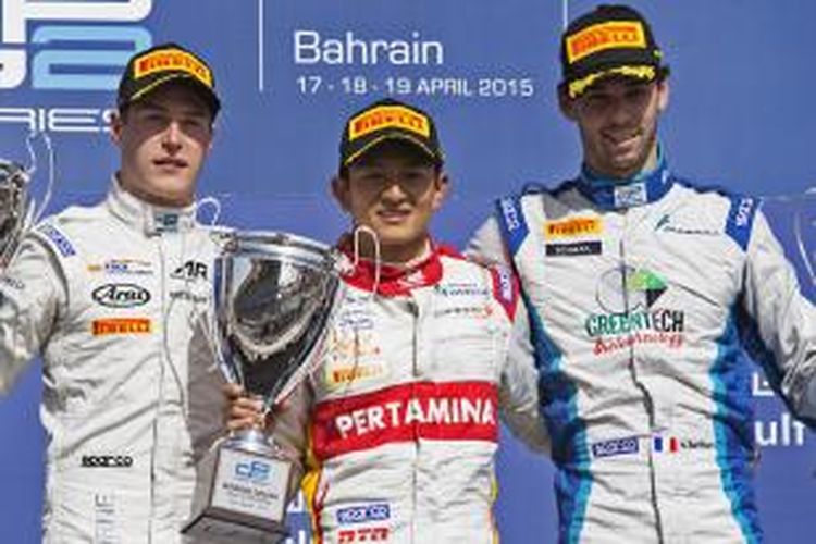 Pebalap Indonesia dari tim Campos Racing, RIo Haryanto (tengah), berpose di atas podium setelah memenangi feature race GP2 Series Bahrain, Minggu (19/4/2015).