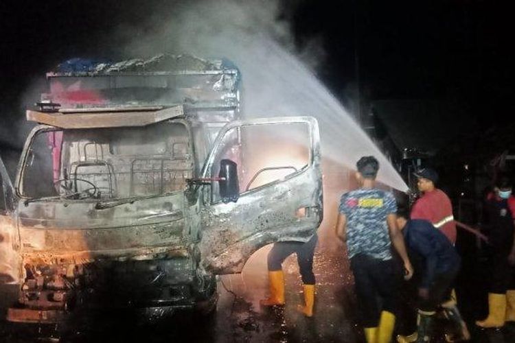 Petugas BPBD Aceh Timur, memadamkan truk bermuatan sawit yang dibakar di Jalan Peureulak-Peunaron, Dusun Sikabot, Seumanah Jaya, Ranto Peureulak, Aceh Timur, Selasa (5/5/2020) malam. (Serambinews.com/Istimewa)