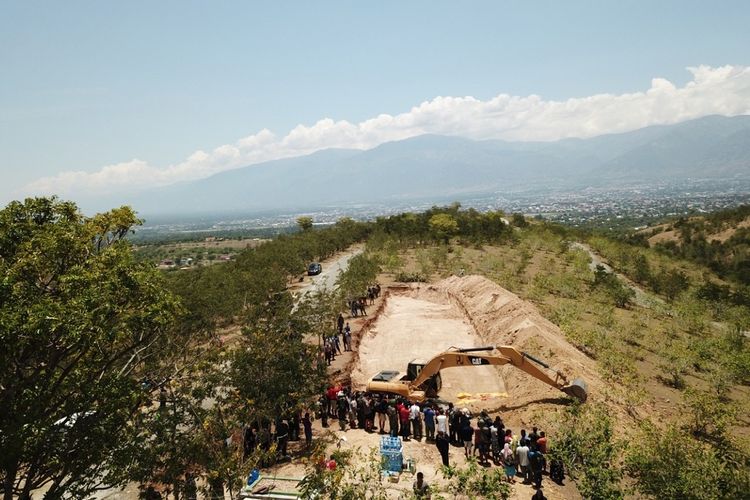 Suasana prosesi pemakaman massal korban gempa tsunami palu di Poboya, Mantikulore, Palu, Senin (1/10). Sebanyak 18 jenazah dimakamkan secara bersamaan, dan dilakukan secara bertahap.