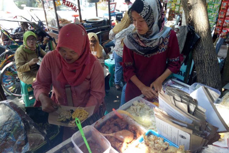 Penjual Rujak Sambal Asam, Turi Nuryati (35), sedang melayani pesanan. Meski lapaknya di salah satu sudut Pasar Kanoman, Cirebon, sempit, tetapi selalu penuh pembeli. Sajiannya menjadi salah satu ikon Pasar Kanoman.
