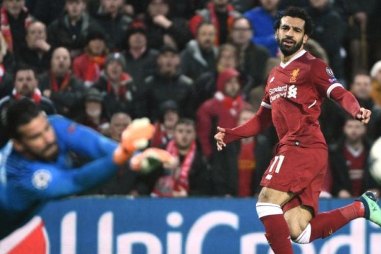 Striker Liverpool, Mohamed Salah (kanan), melepaskan tembakan yang coba dihalau kiper AS Roma, Alisson Becker, dalam partai Liga Champions di Stadion Anfield, Liverpool, 24 April 2018.
