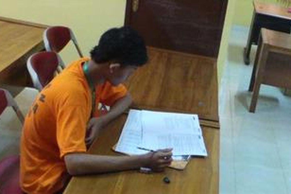 F, tahanan narkoba Kepolisian Resor Metro Jakarta Timur, Senin (15/4/2013), mengikuti Ujian Nasional hari pertama di kantor polisi itu.