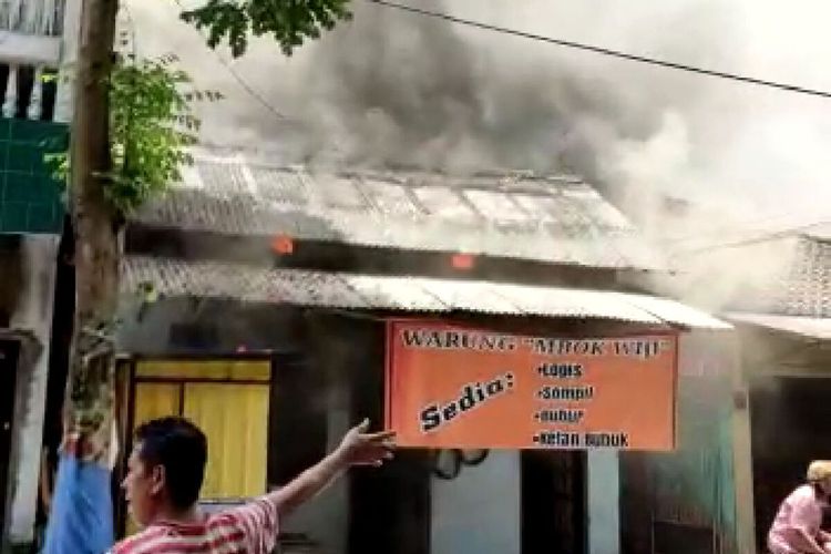 Warga berusaha mengeluarkan perabot rumah mereka setelah rumah di Jalan Kelud Bo. 42, Kota Blitar terbakar akibat korsleting listrik, Sabtu (4/3/2023)