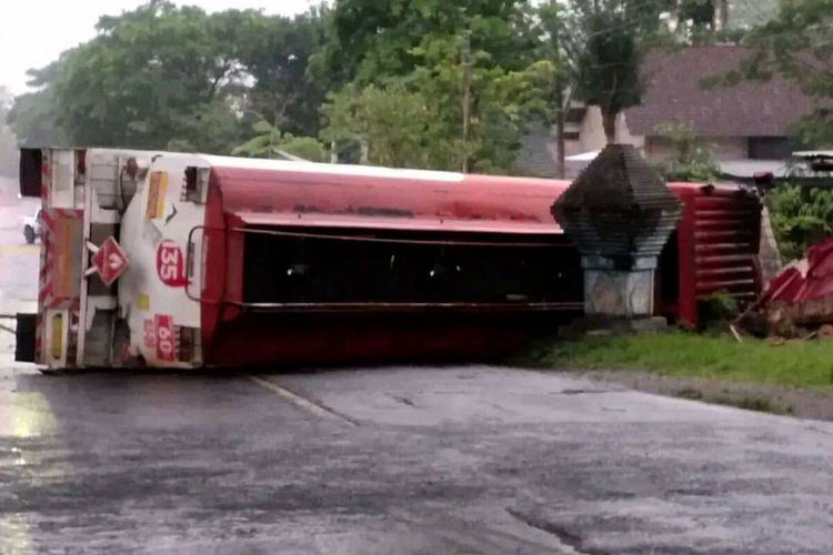 Truk tangki Pertamina dengan muatan penuh BBM 24.000 liter terguling dan menutup jalan nasional di Kelurahan Bence, Kecamatan Garum, Kabupaten Blitar, Kamis (6/10/2022)