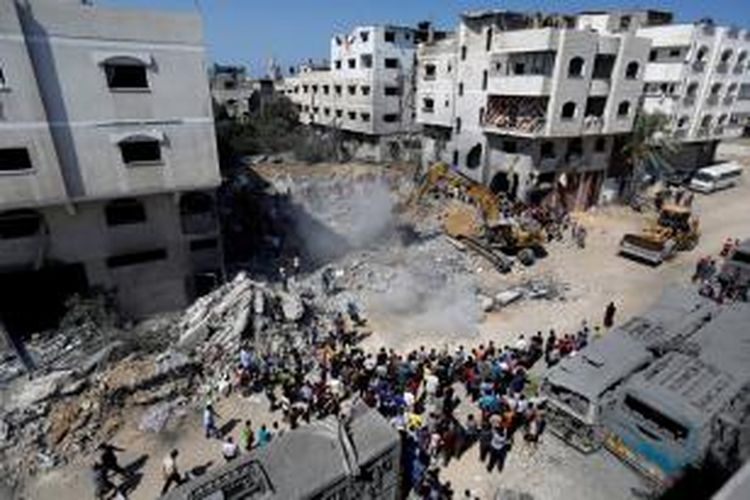 Warga berkumpul di lokasi kediaman pemimpin militer Hamas, Mohammed Deif di Jalur Gaza yang hancur akibat serangan udara Israel
